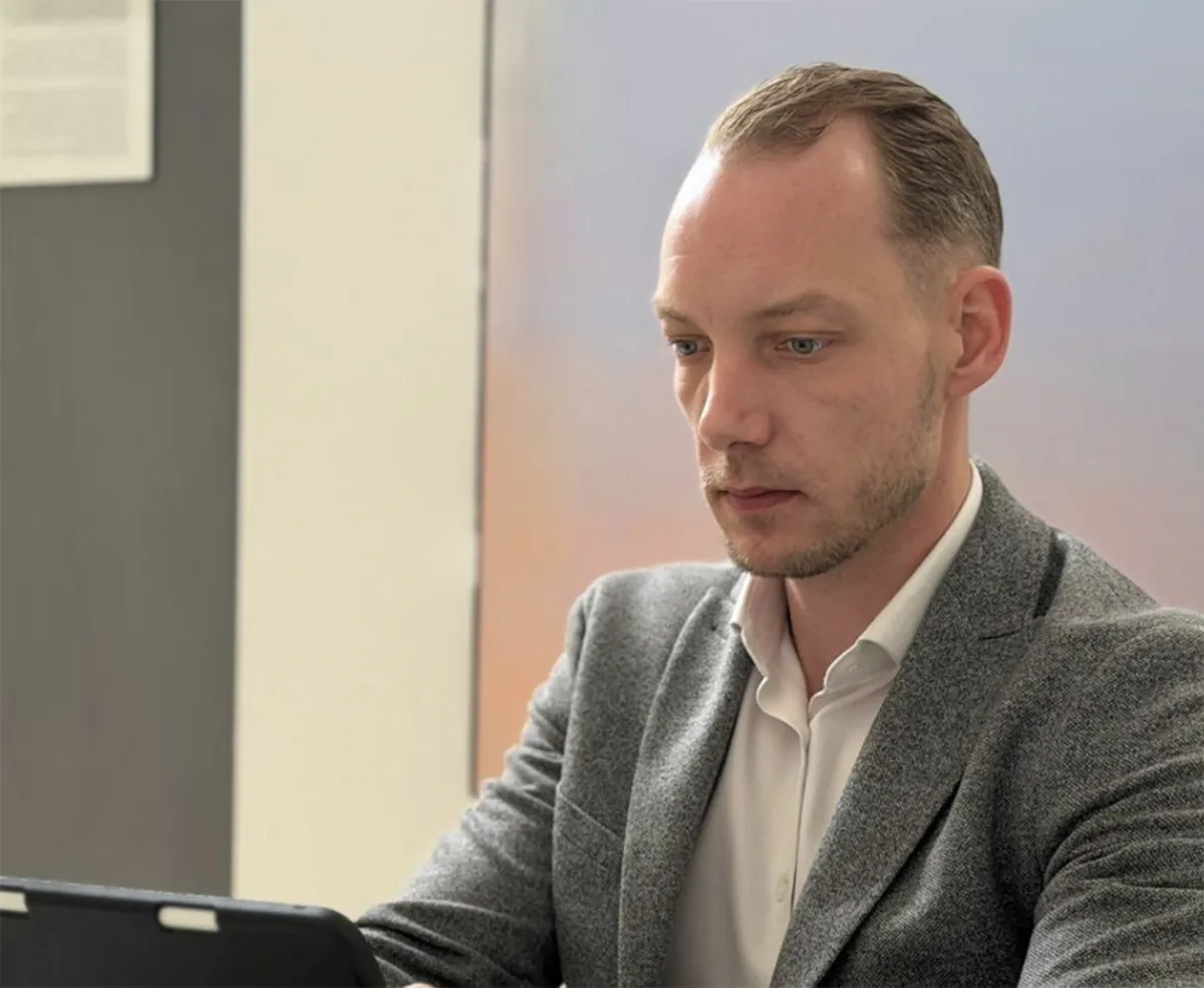 Ein Interim Manager von Aurum sitzt in einem hell ausgeleuchtetem Büro vor seinem Laptop